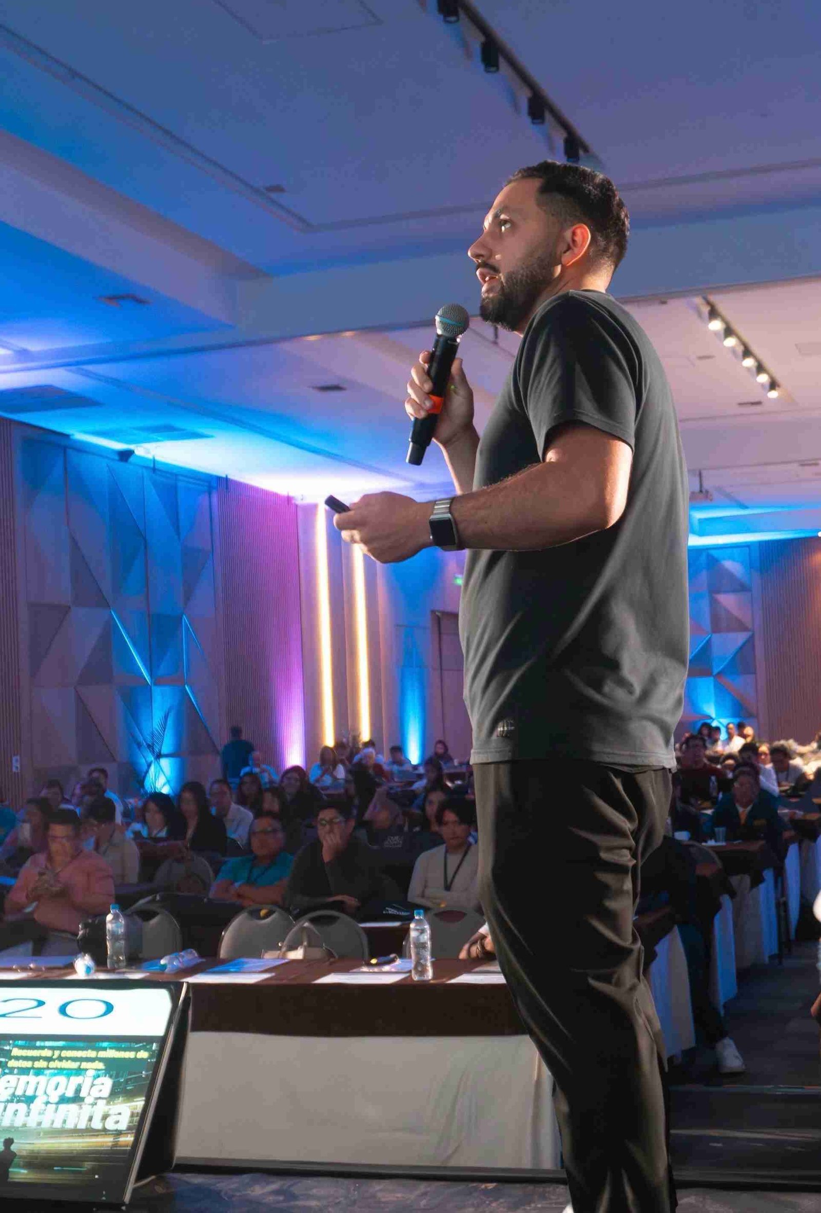 David Arévalo hablando con micrófono en un evento, foto publicada por Kambio Edu
